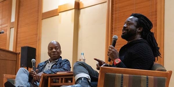 Marlon James speaking with SFIS Assistant Professor Michael Bennett