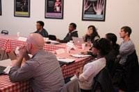 Students sitting at tables listening to lecture.