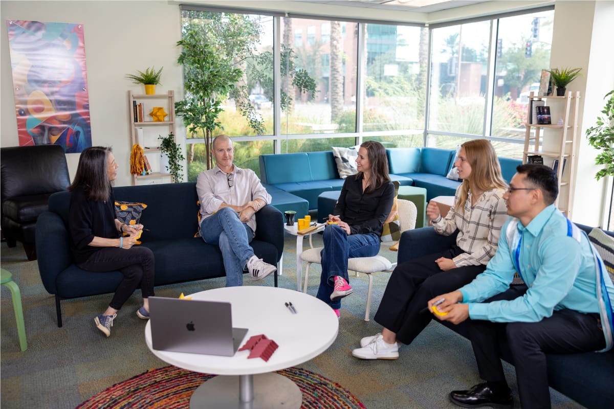 There are people sitting in an office talking to each other